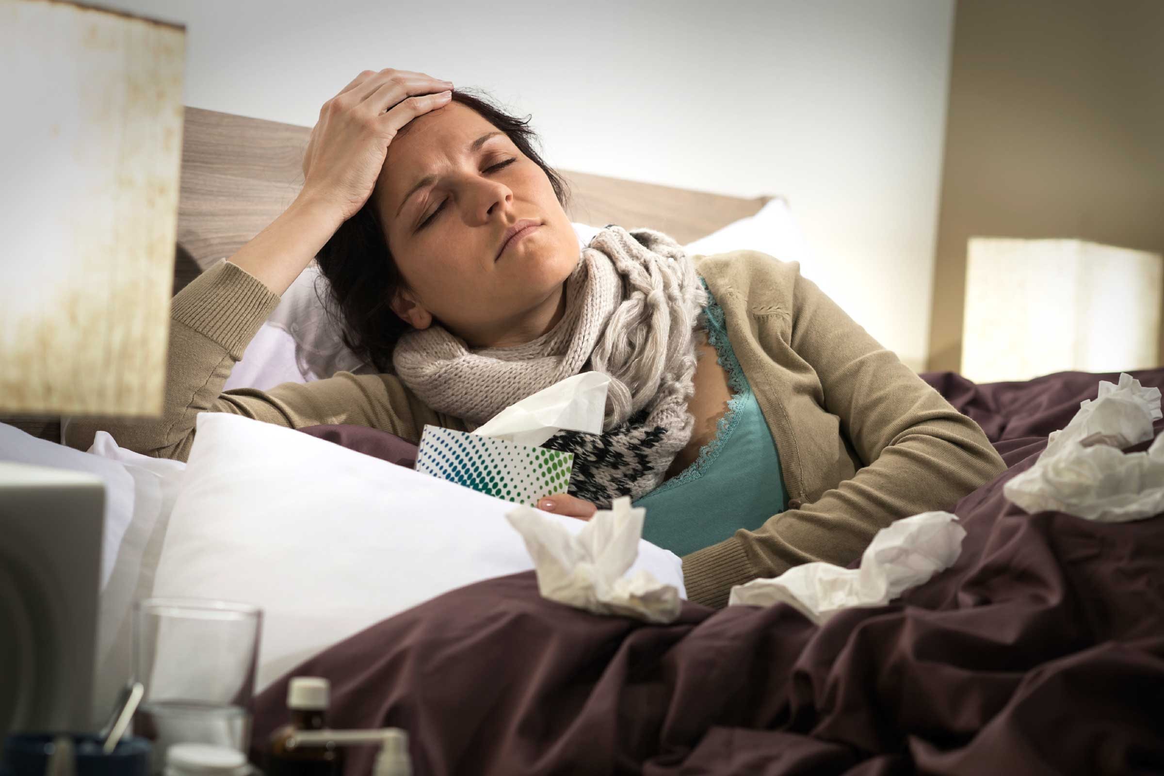 signs getting sweating|Woman lying in bed propping herself up on one elbow and holding her forehead while holding a box of tissues in the other hand.|Woman in a tank top drinking water from a water bottle.|Woman lying on a couch holding her stomach with her left hand.|Woman sitting on a couch covered in a blanket holding a thermometer in her left hand.|Woman lying on a bed eating a bowl of chicken soup and holding her forehead with her left hand.|Woman lying on a bed propping her head up with one hand and using her cellphone in the other hand.|Woman sleeping on a bed near a white nightstand that has a glass of water on it.