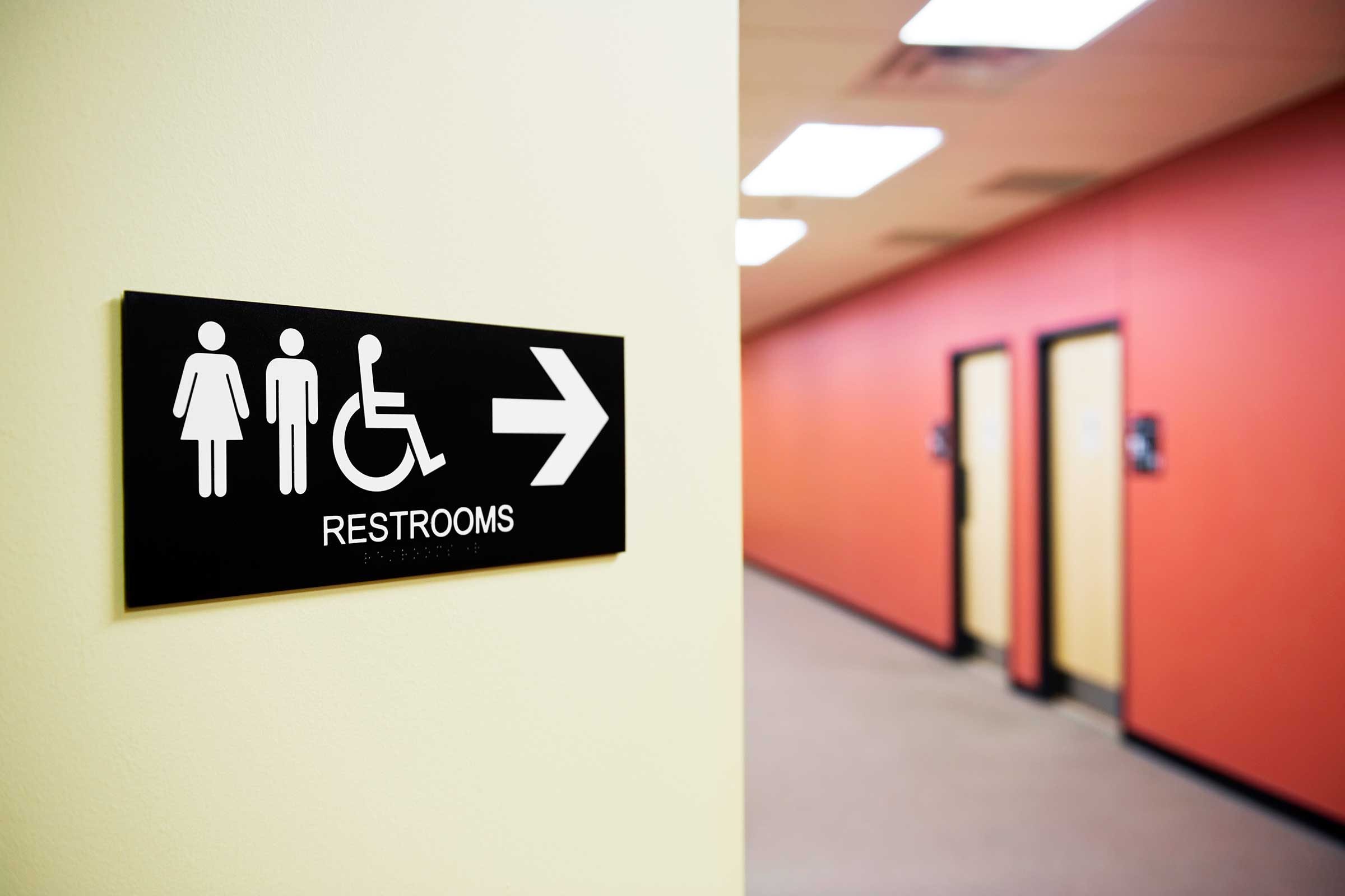 sign pointing to restrooms|close up of young woman pouring herself a glass of water at home