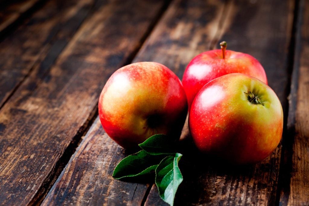 Eat-These-5-Fruits-Daily-to-Control-Your-Weight|bowl of blueberries and scattered blueberries on a dark background|red apples on weathered wood table|pears glistening with water|strawberries on a deep blue dish|variety of peppers