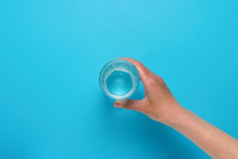 Female hand taking a glass of water.