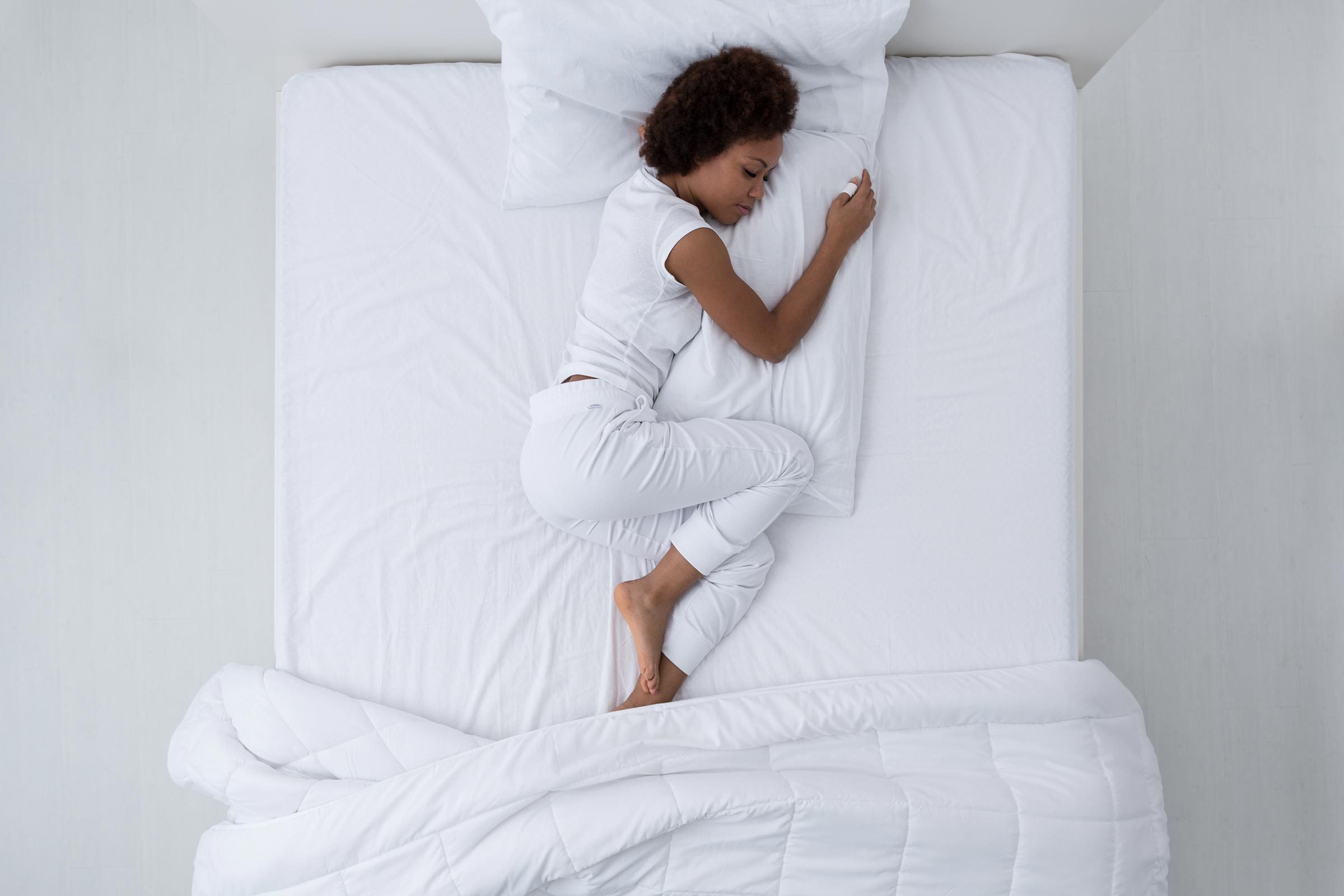 Beautiful african american woman lying in bed and sleeping, top view|Beautiful african american woman lying in bed and sleeping, top view