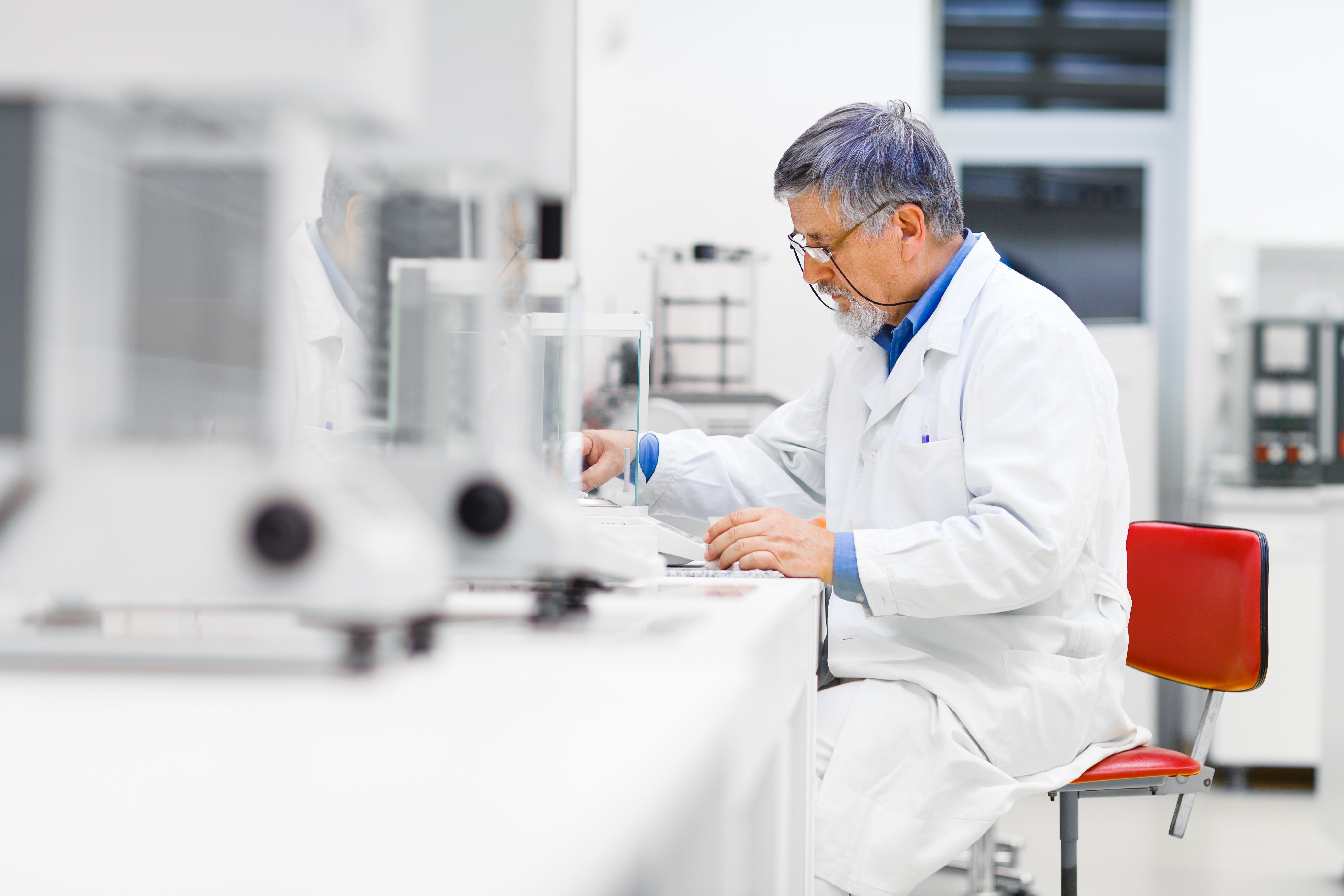 Senior male researcher carrying out scientific research in a lab (shallow DOF; color toned image)