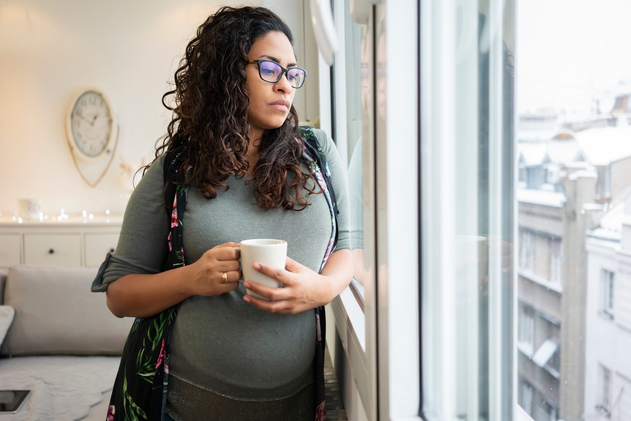 Pregnant woman drinking coffee at home|