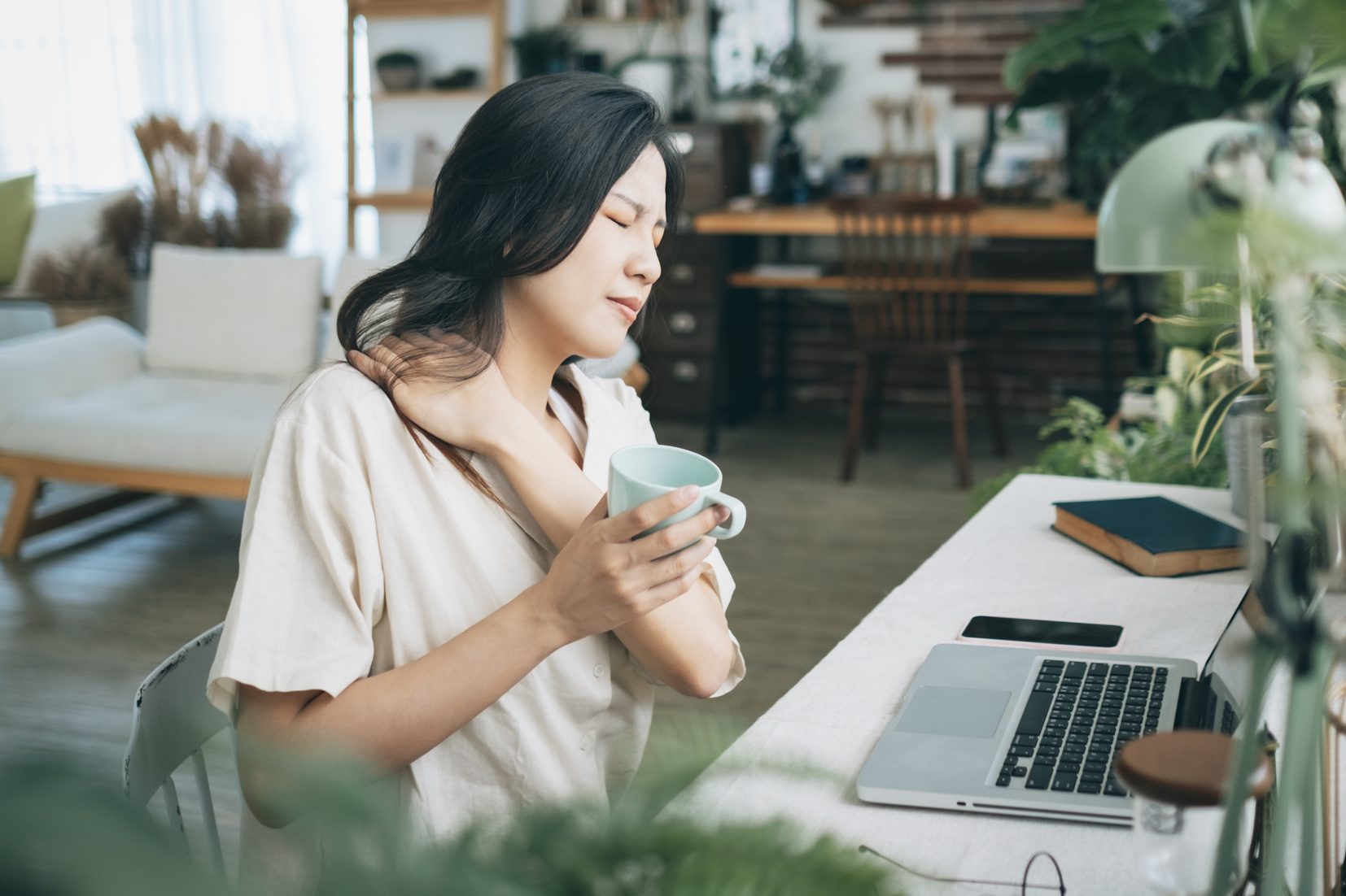 Asian woman struggling with using laptop at home