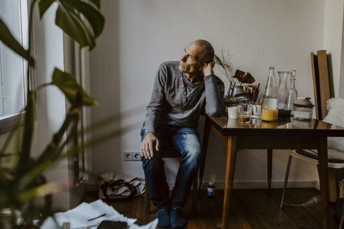 worried senior man sitting on chair in living room and looking out the window|worried senior man sitting on chair in living room and looking out the window|Female patient sharing problems with therapist