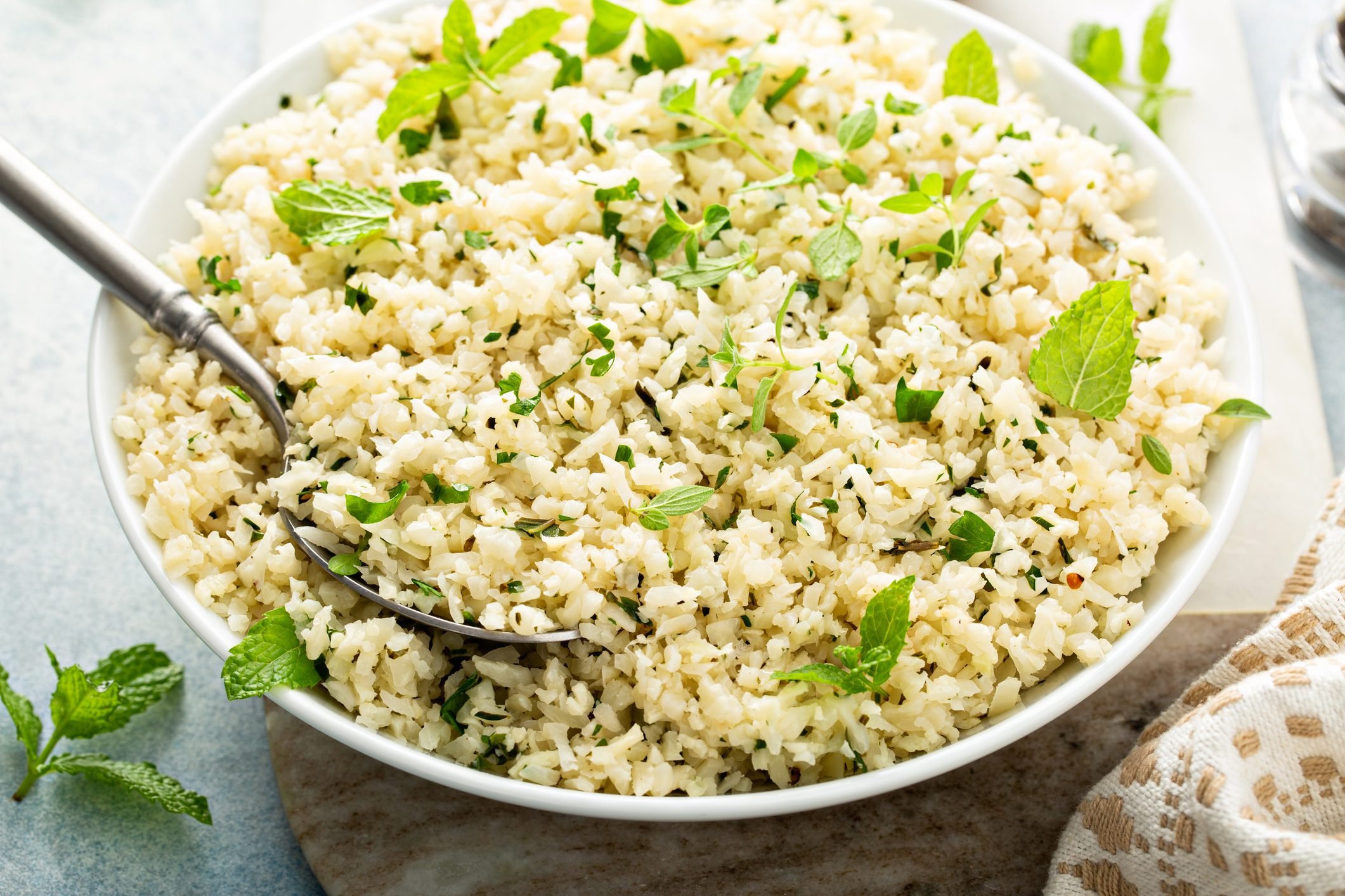 Cauliflower rice with herbs and lemon juice in a white bowl