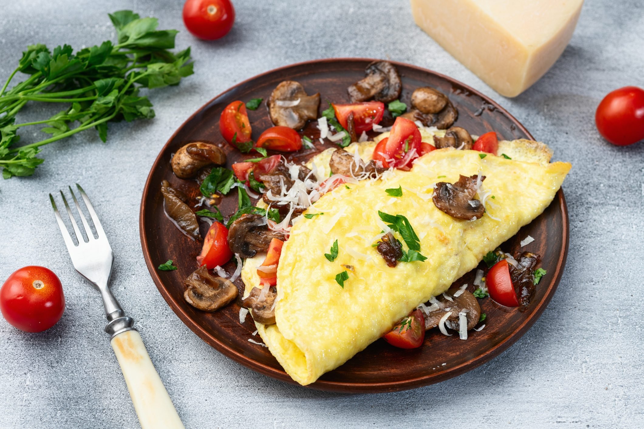 Omelette stuffed with mushrooms , tomatoes and parsley