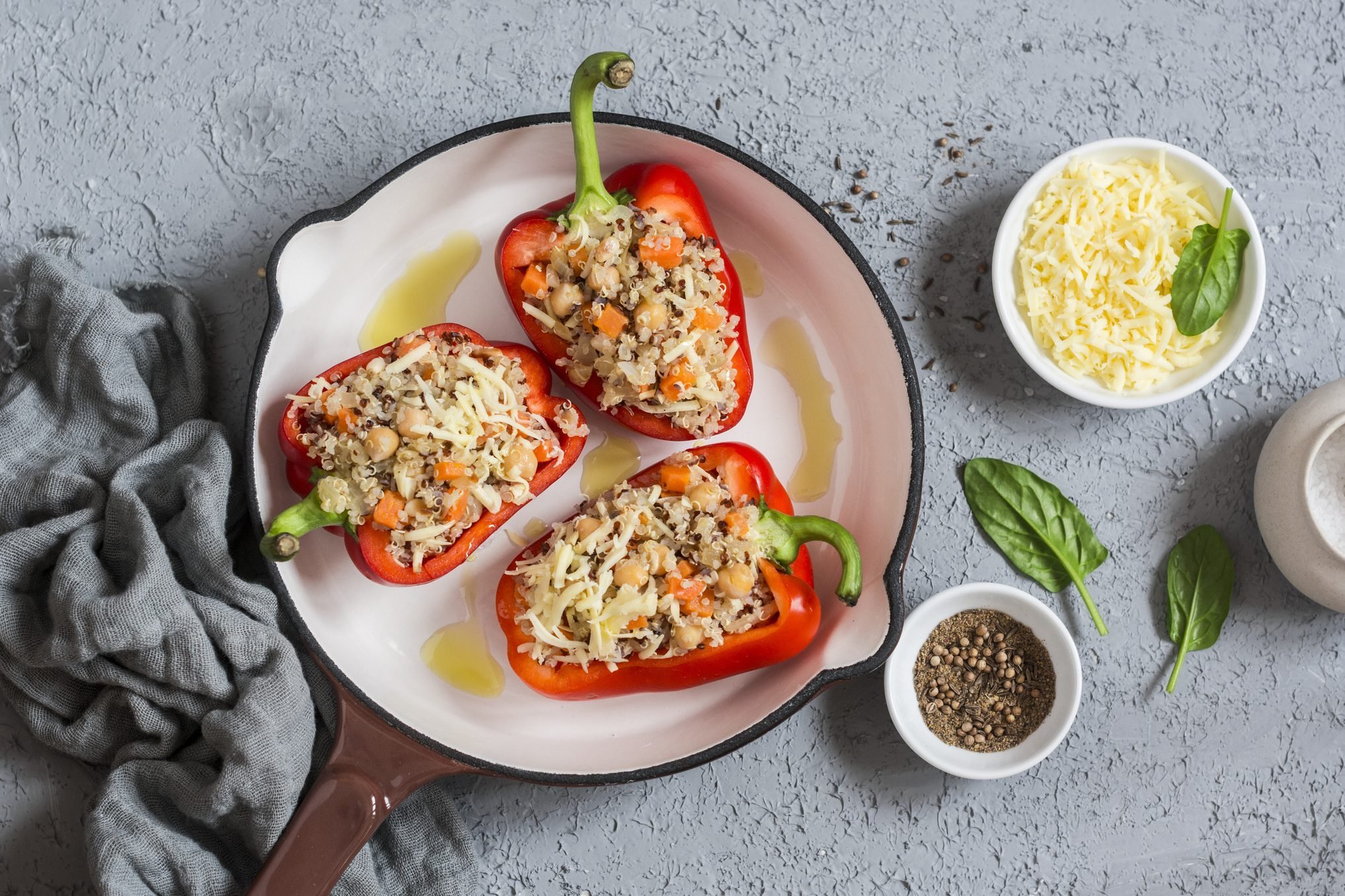 Raw quinoa stuffed sweet peppers in a cast iron skillet. Top view. Healthy, vegetarian food concept