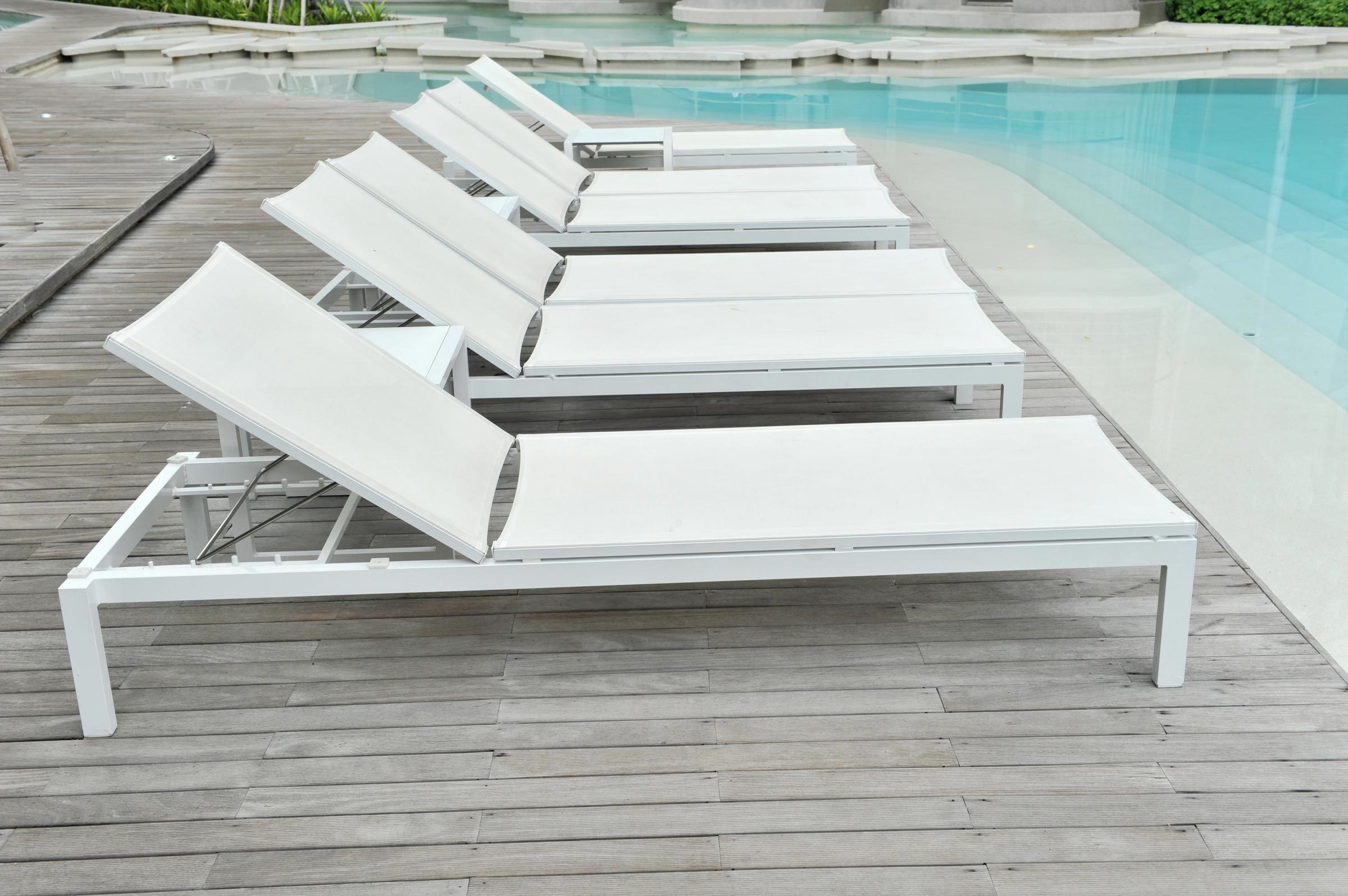 outdoor lounge chairs by the pool in summer