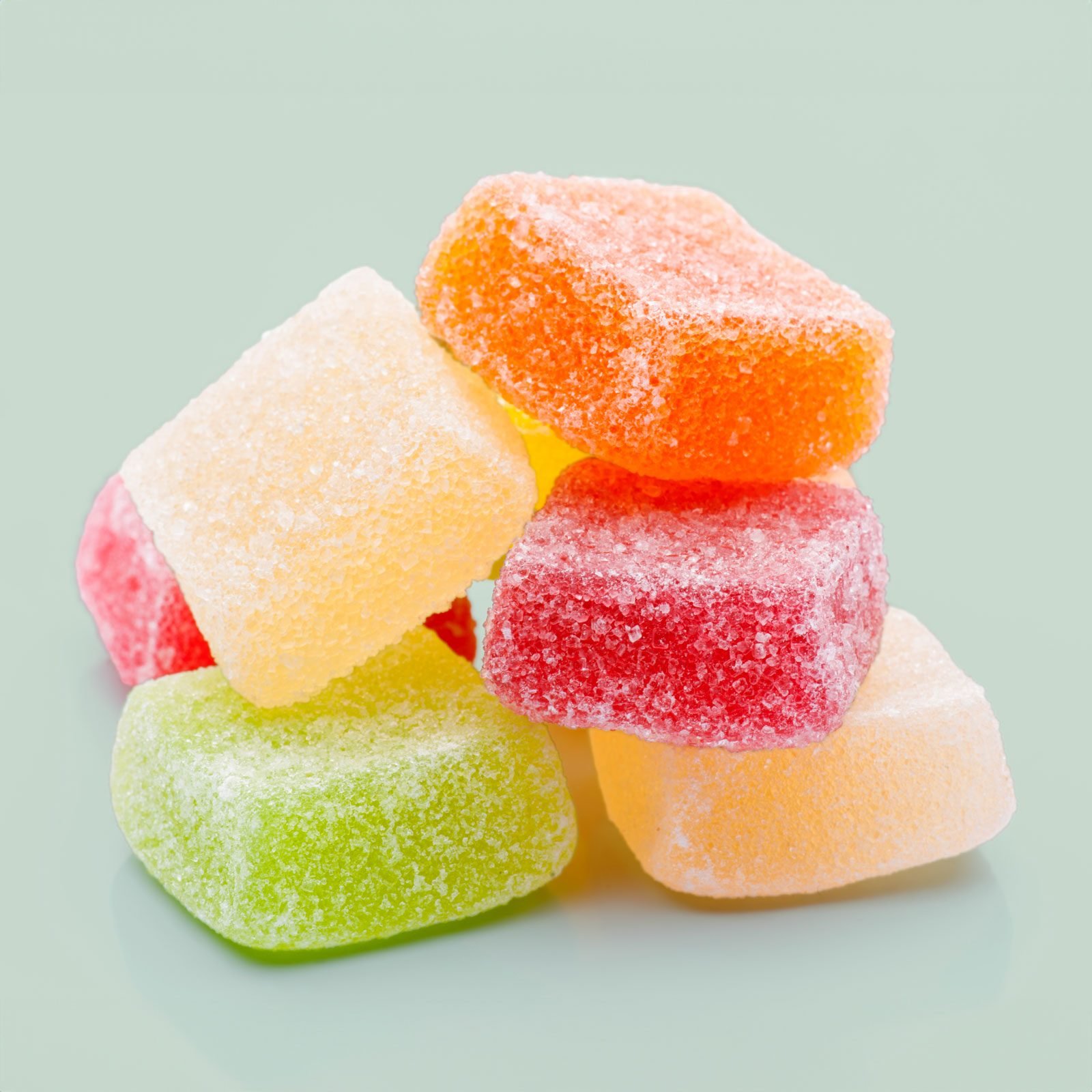 colorful edible gummies on a light greeen background
