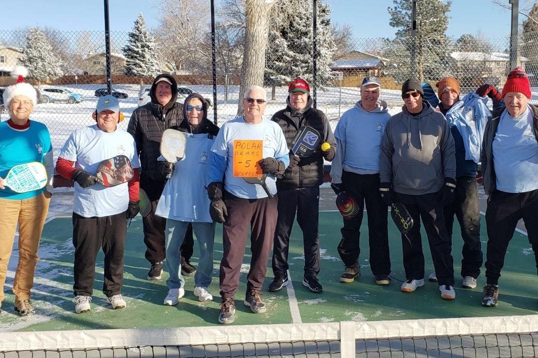 group photo of mature adults playing pickle ball