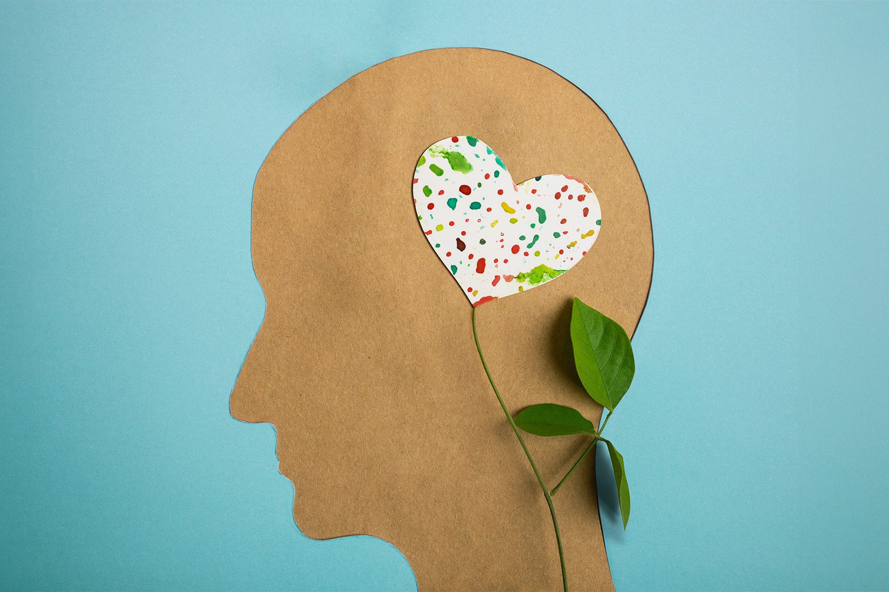 Paper Cut as Human Head with Leaf Tree and Colorful Heart Shape Flower inside the Brain. Psychology, Creativity and Positive Mind Concept