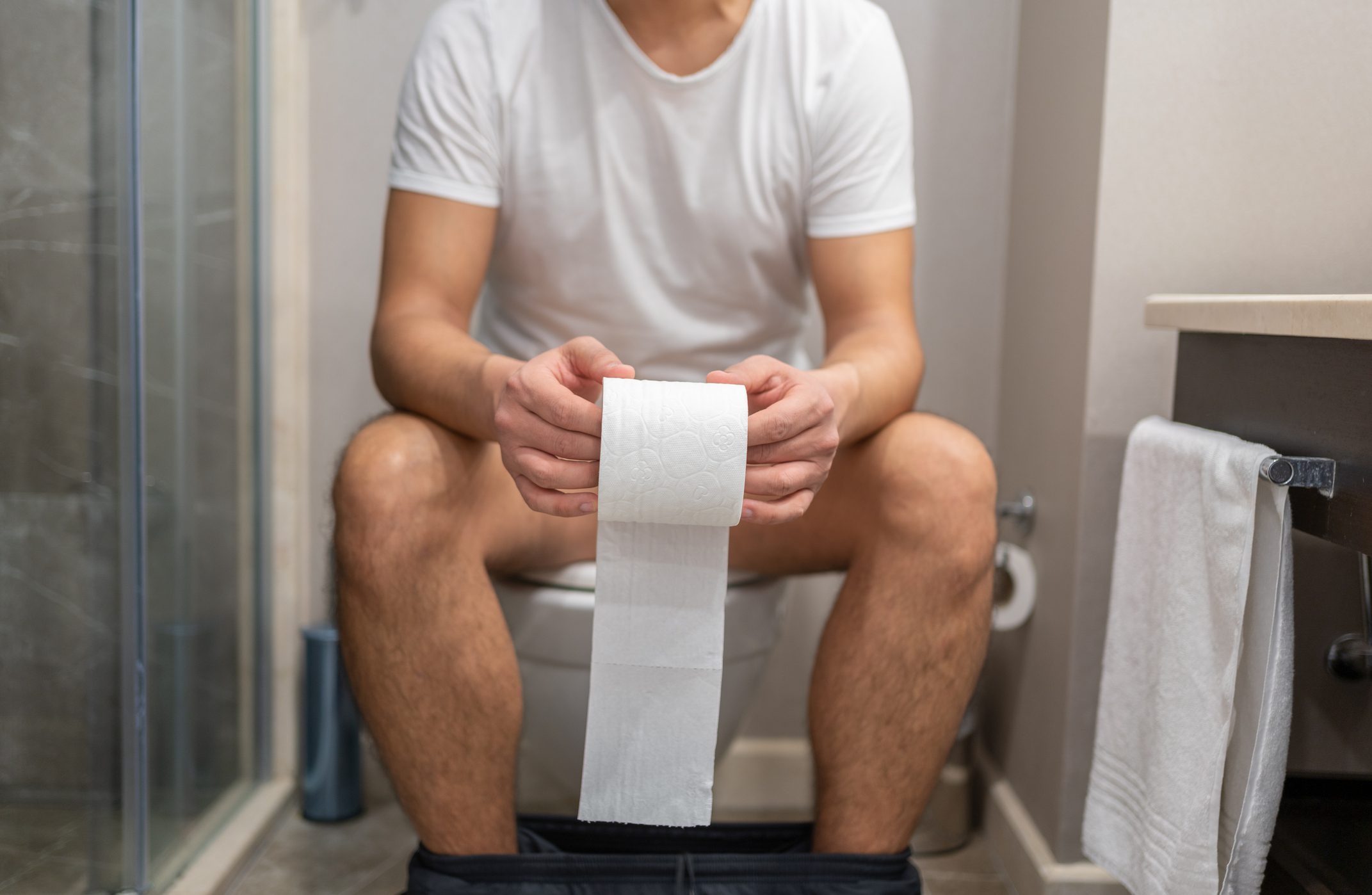 Man Sitting On Toilet With Toilet Paper İn Hand