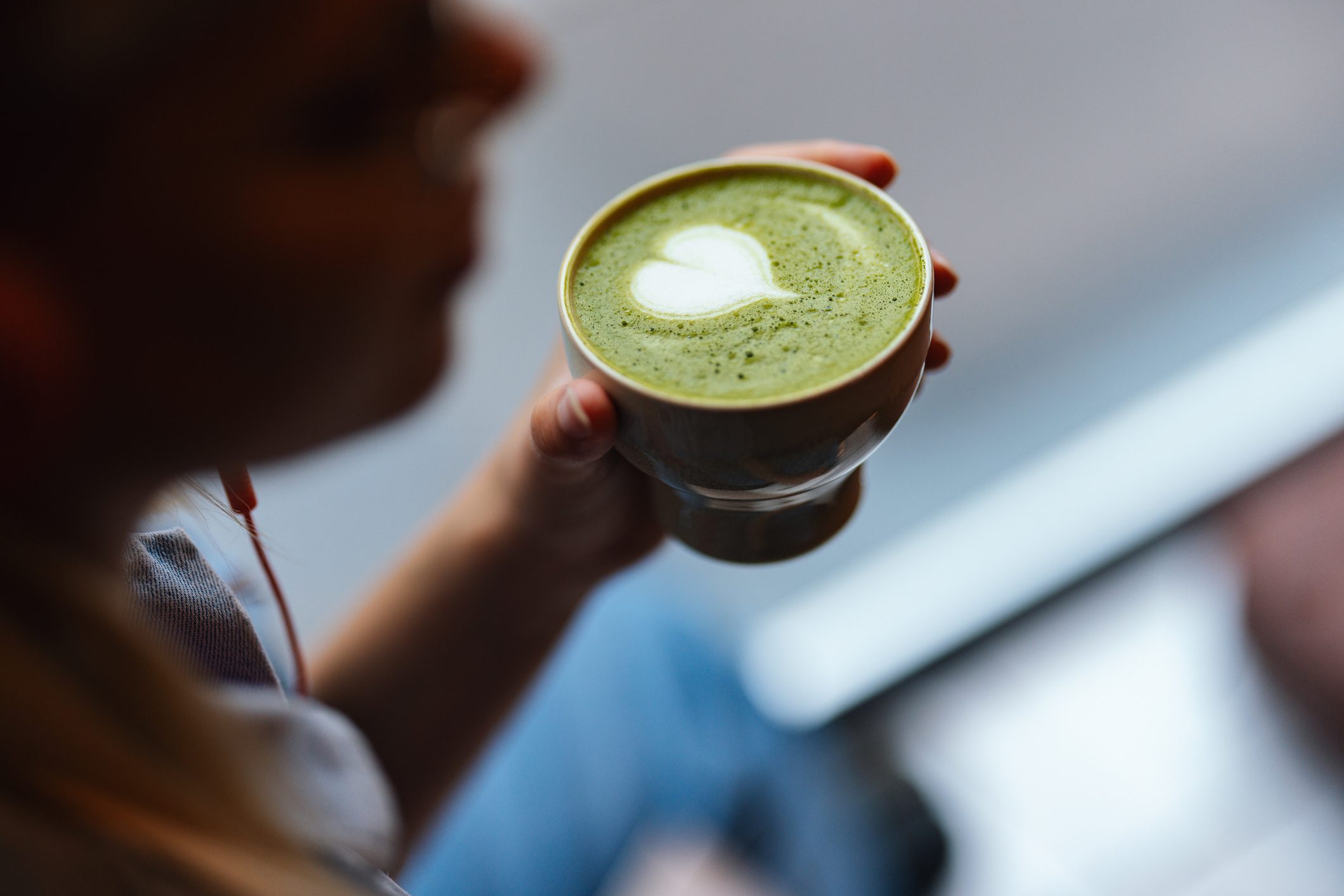 Woman Enjoys Drinking Delicious Matcha Tea With Green Foam