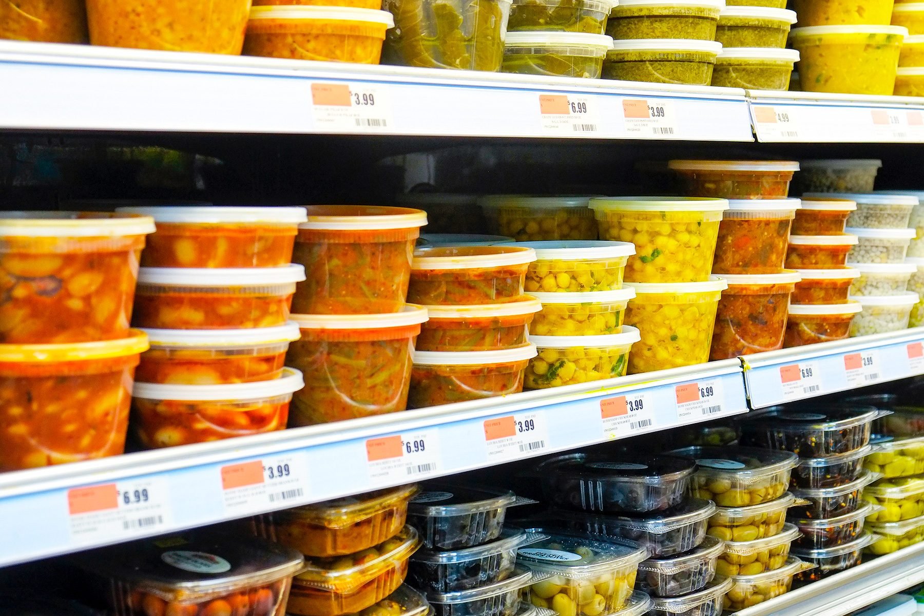 An array of food items on a well-stocked grocery store shelf.|