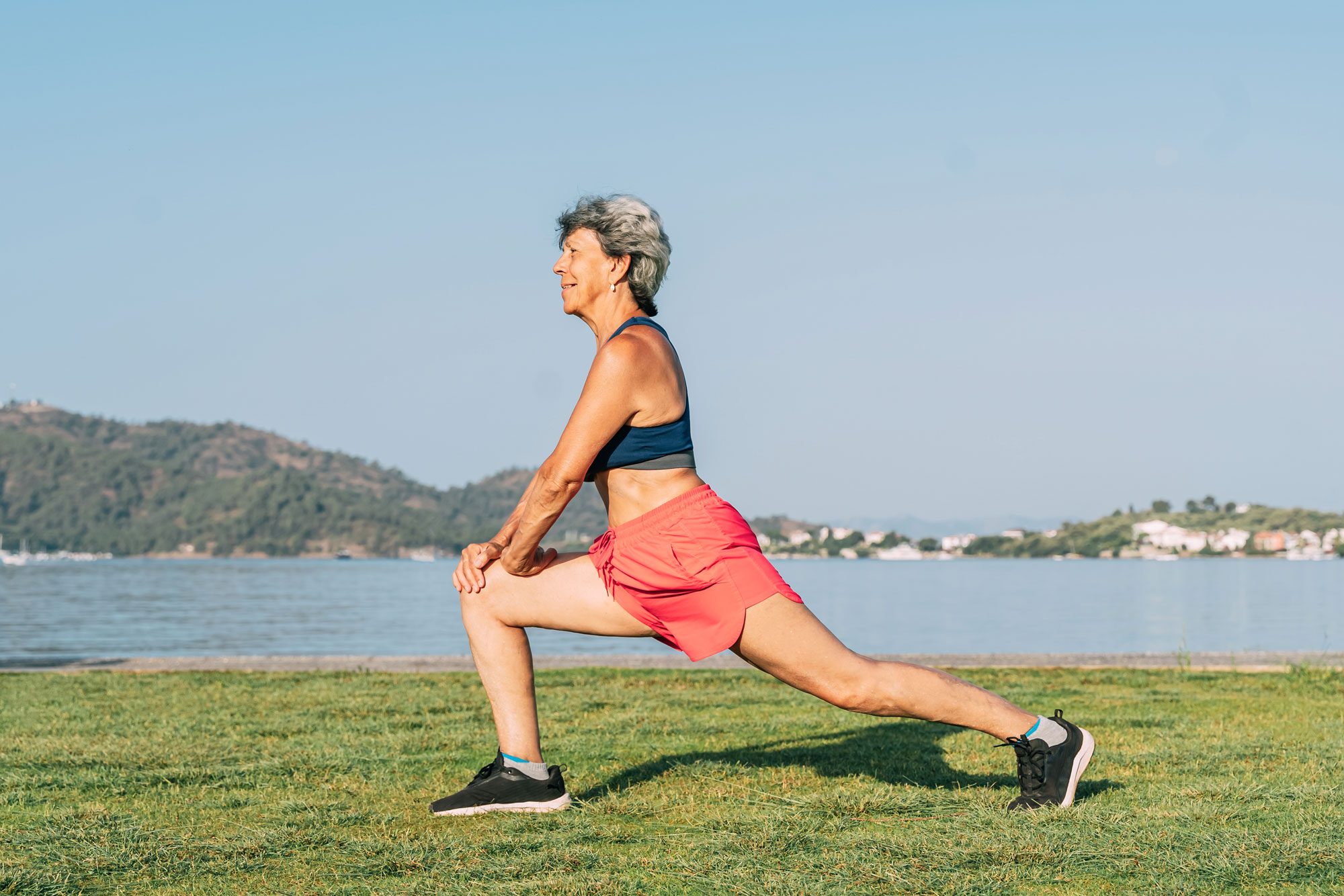 Senior Gray Haired Woman Doing Exercises In Public Park